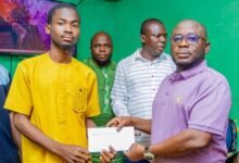 • Mr Abdul-Ganiu Sandoo presenting the receipt of the fees to a beneficiary