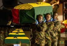 • Military personnel carrying one of the victims at the Airforce base, Burma camp