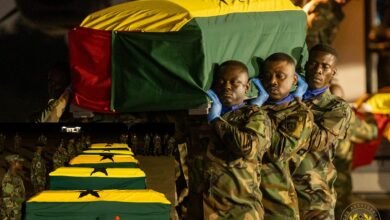 • Military personnel carrying one of the victims at the Airforce base, Burma camp