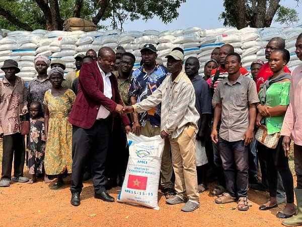 Mr Demordzi (left) presenting the fertilizers to the farmers