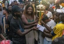 Mr Amoako Boafo presenting the winners trophy to skipper Jacob Ansah of Osu