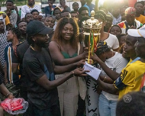 Mr Amoako Boafo presenting the winners trophy to skipper Jacob Ansah of Osu