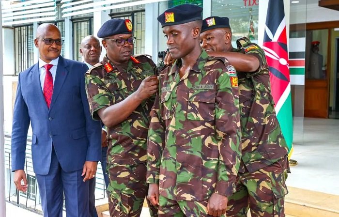 • Muchiri being decorated by Major General Kutto while General Kahariri (in suit) looks on