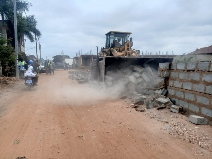 • A fence wall constructed on an access road being demolished