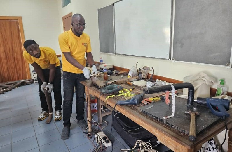 Technicians working on the prosthetic limbs. (Inset) Some of the prosthetic limps