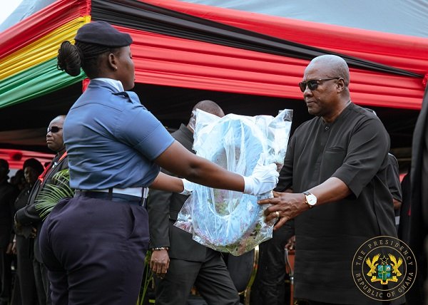 President Mahama receiving a wreath to be laid in memory for the departed souls at the military cemetary