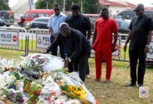 • SWAG President Kwabena Yeboah lays a wreath while some members look on