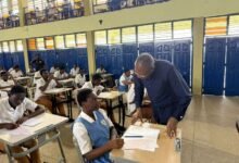 • Dr Apaak interacting with a student at an exams centre