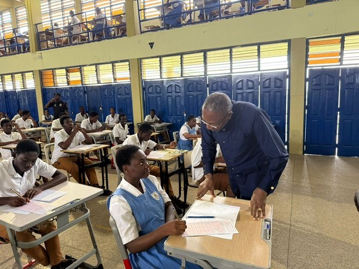 • Dr Apaak interacting with a student at an exams centre