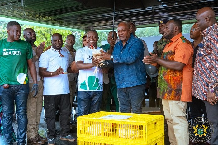 • President Mahama (third from right) being presented with a fowl during his visit to the farm