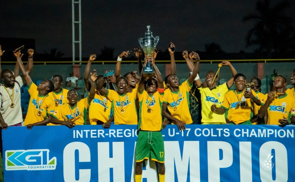 Captain of Ashanti, Agyei Duah, lift high the winner's trophy while his teammates celebrate