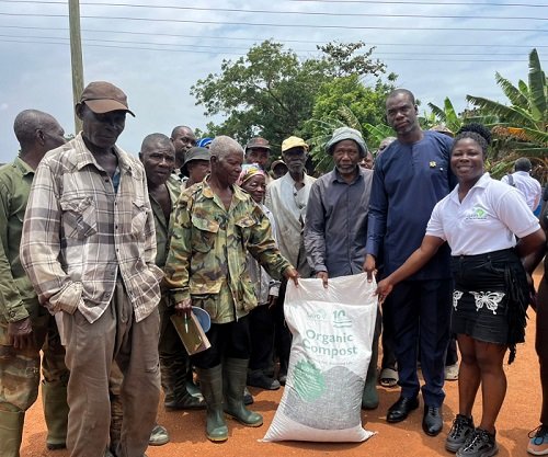 • Ms Laryea ( right) with Mr Anyetei (second from right) presenting the fertiliser to the farmers