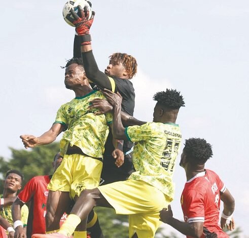 • Kotoko goalkeeper Camara Mohammed grabs the ball away from two Gold Stars players during the game