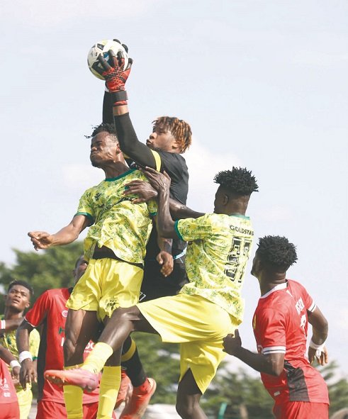 • Kotoko goalkeeper Camara Mohammed grabs the ball away from two Gold Stars players during the game
