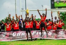 • Martin Buabeng lifts high the winner's trophy while his team mates celebrate