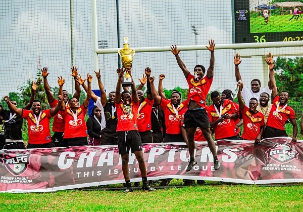 • Martin Buabeng lifts high the winner's trophy while his team mates celebrate