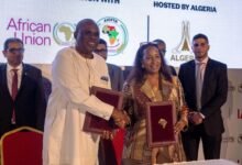 Prof Oramah exchanging the signed document with Ms Coke-Hamilton