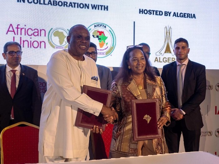 Prof Oramah exchanging the signed document with Ms Coke-Hamilton