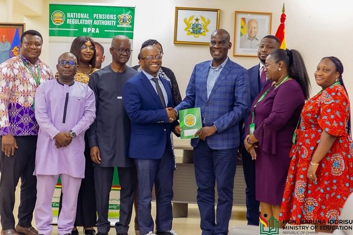 Mr Boadi-Mensah (fifth from left) presenting a copy of the book to Mr Iddrisu (fourth from left), while other senior staff of the two institutions look on