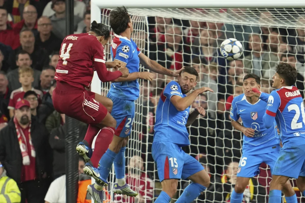 • Virgil van Dijk(left)heads home the third goal during the game between Liverpool and Atletico Madrid