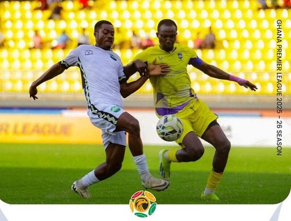 A player of Dreams FC (in white) and Medeama (right) battle for possession in this scene