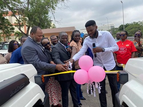 • Inset, Mr Armah-Kofi Buah (middle) being assisted by Prof Nana Ama Browne Klutse (second from right) and others to cut the tape to commission the vehicles