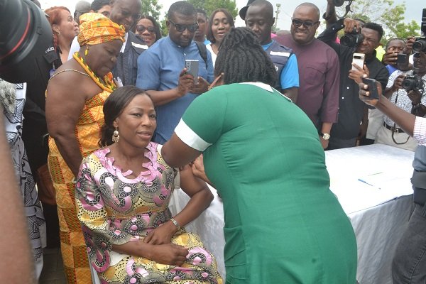 • Prof. Dr Grace Ayensu-Danquah (seated), Deputy Minister of Health, being vaccinated by a nurse at the programme Photo: Victor A. Buxton