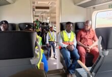 Mr Nikpe (far right) in a tete-a-tete with Dr Appoh onboard the train