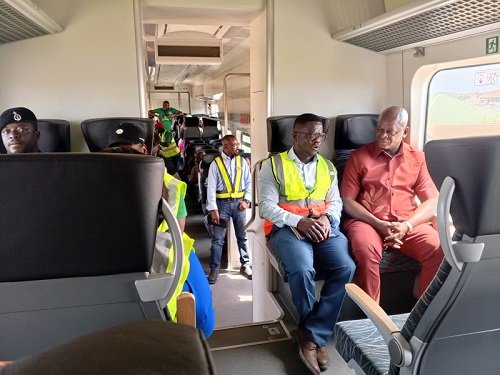 Mr Nikpe (far right) in a tete-a-tete with Dr Appoh onboard the train