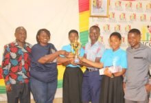 Mrs Gloria A. Kudo (left) presenting the winner trophy to all Saints Anglican Model Basic School. Photo: Ebo Gorman