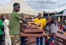 Nii Kotey Ashie(middle) presenting the items to a beneficiary
