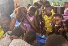 Ms Laryea training some students on how to use T-shirt to make a bag