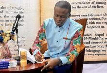 Mr Michael Danso signing a copy of the book