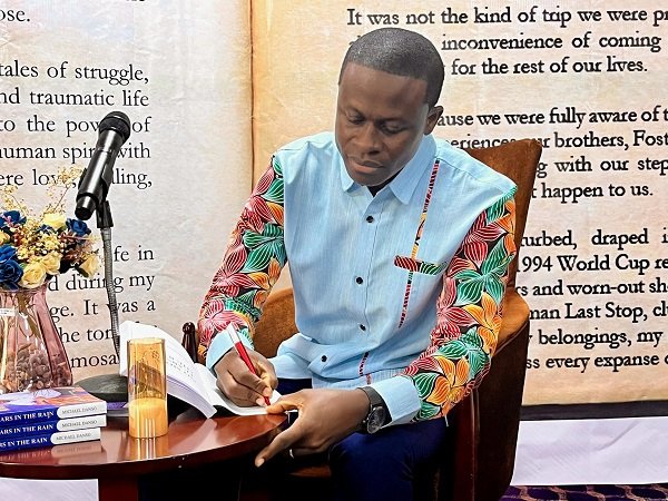Mr Michael Danso signing a copy of the book