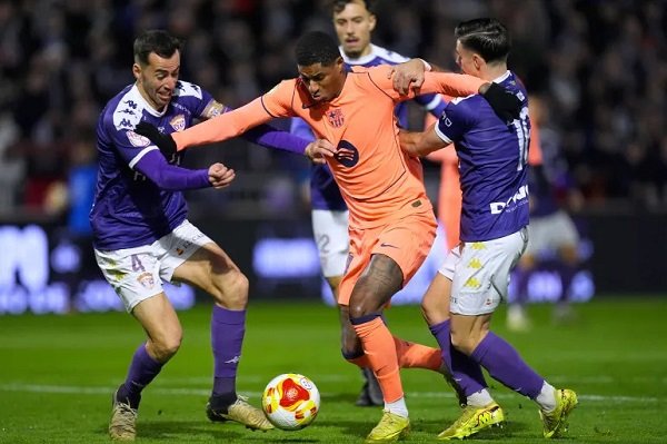 Barcelona's Marcus Rashford is challenged by his opponents during the game