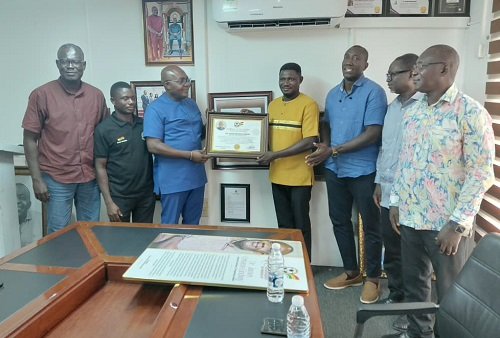 • Dr Orleans-Lindsay (third left) receiving the citation from Chris Ekpor. Looking on are members of the GDFF