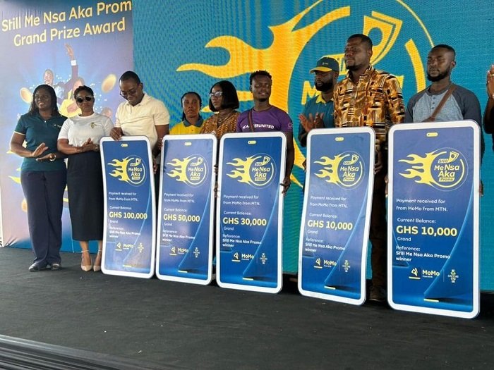 Winners of the promotion displaying their dummy cheques