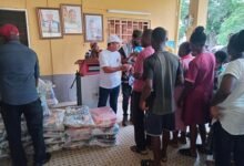 Mr Asatarri (in white T.Shirt and cap) distributing the rice to the people