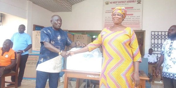 Mr Francis Profer Duse (left) presenting an industrial sewing machine to a beneficiary