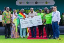 President Mahama (sixth from right) presenting the overall National Best Farmer dummy cheque to Mr Abraham Kwaku Adusei (third from left)