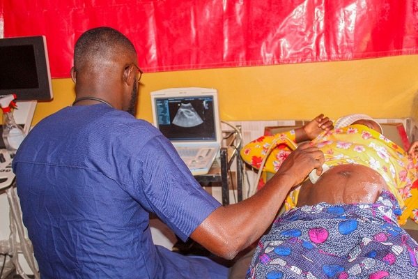 • A health worker screening a pregnant woman