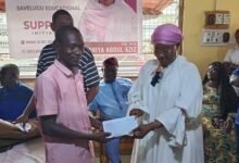 • Hajia Fathahiya Abdul-Aziz presenting the funds to one of the beneficiary students