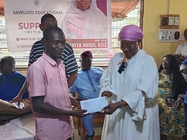 • Hajia Fathahiya Abdul-Aziz presenting the funds to one of the beneficiary students