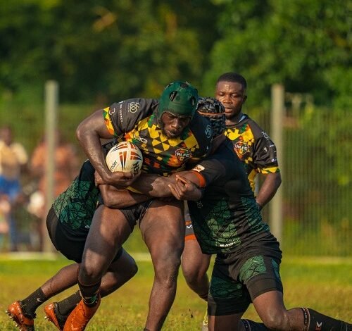 Ghanaian player fends off a double challenge from his two Nigerian markers