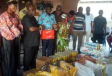 The Volta Regional Minister, Mr James Gunu (left) presenting the items to the Caretaker of the Cured lepers Village, Mr Gedion Atitso