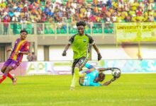 Asare (down) dives to make a save to deny striker Salifu a chance at goal