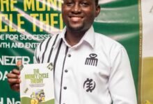 Mr Ebenezer Annoh, displaying a copy of the book at the launch