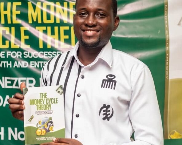 Mr Ebenezer Annoh, displaying a copy of the book at the launch
