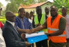 Prof. Kwame Offei (right)presents architectural designs to contractors for the commencement of work