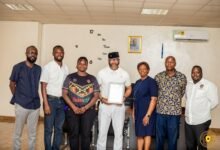 NSA boss Mr Ampofo Ankrah (middle) displaying the certificate. With him are Madam Storey (right) and staff of the RLFG and NSA